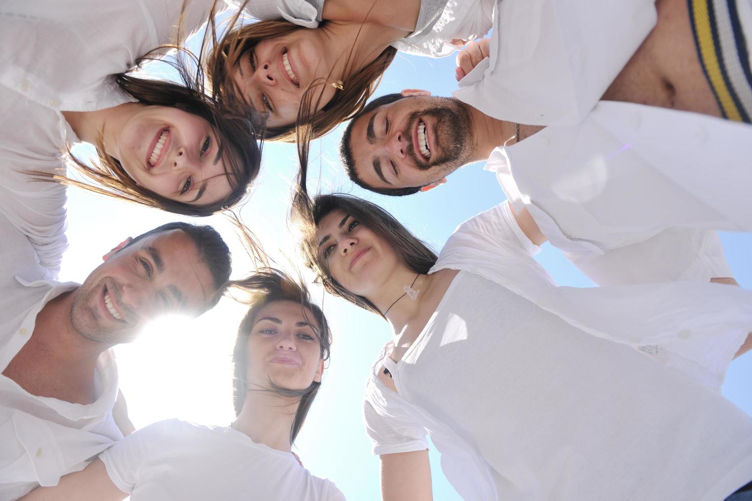 grupo de jóvenes felices en círculo en la playa foto