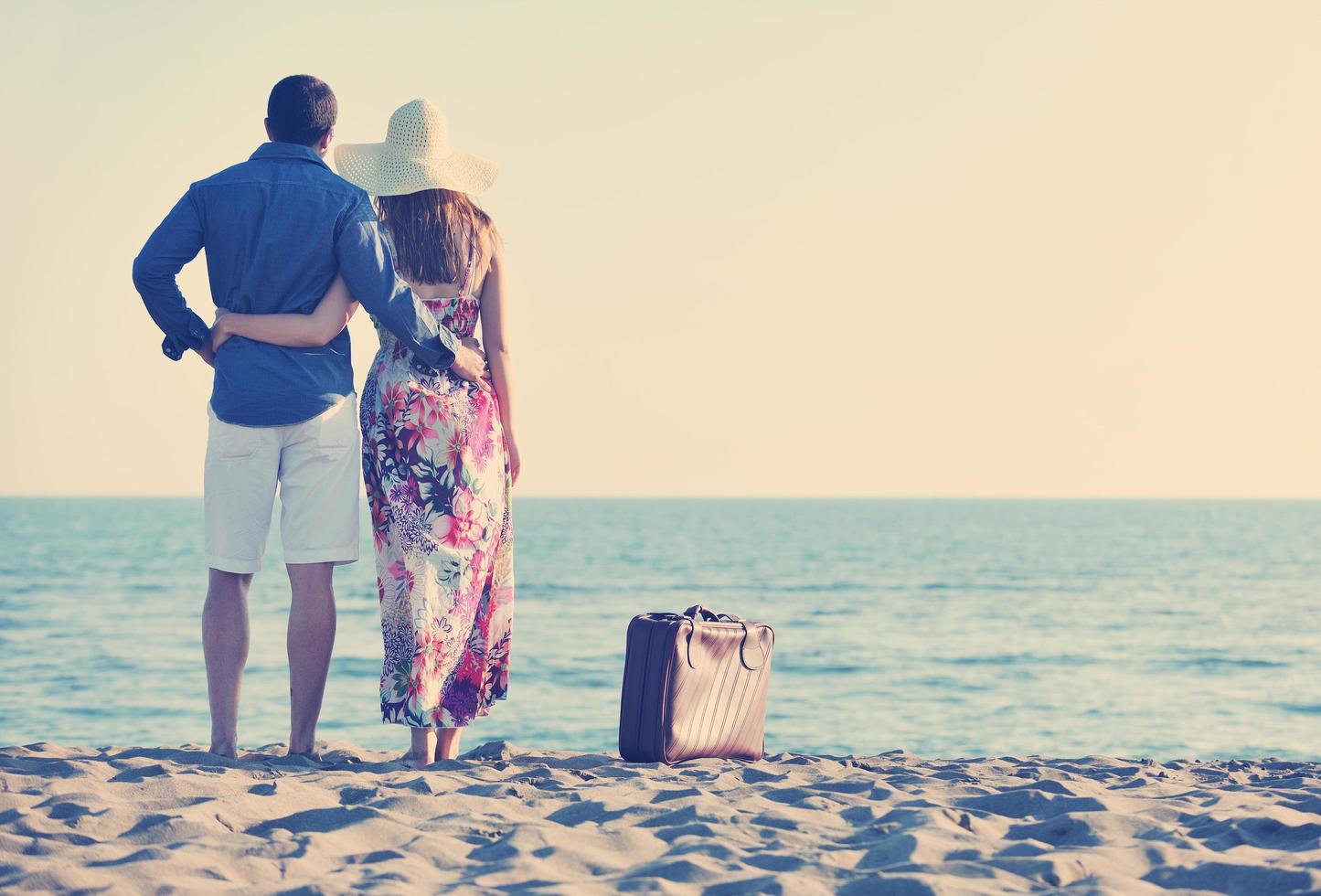 couple on beach with travel bag photo