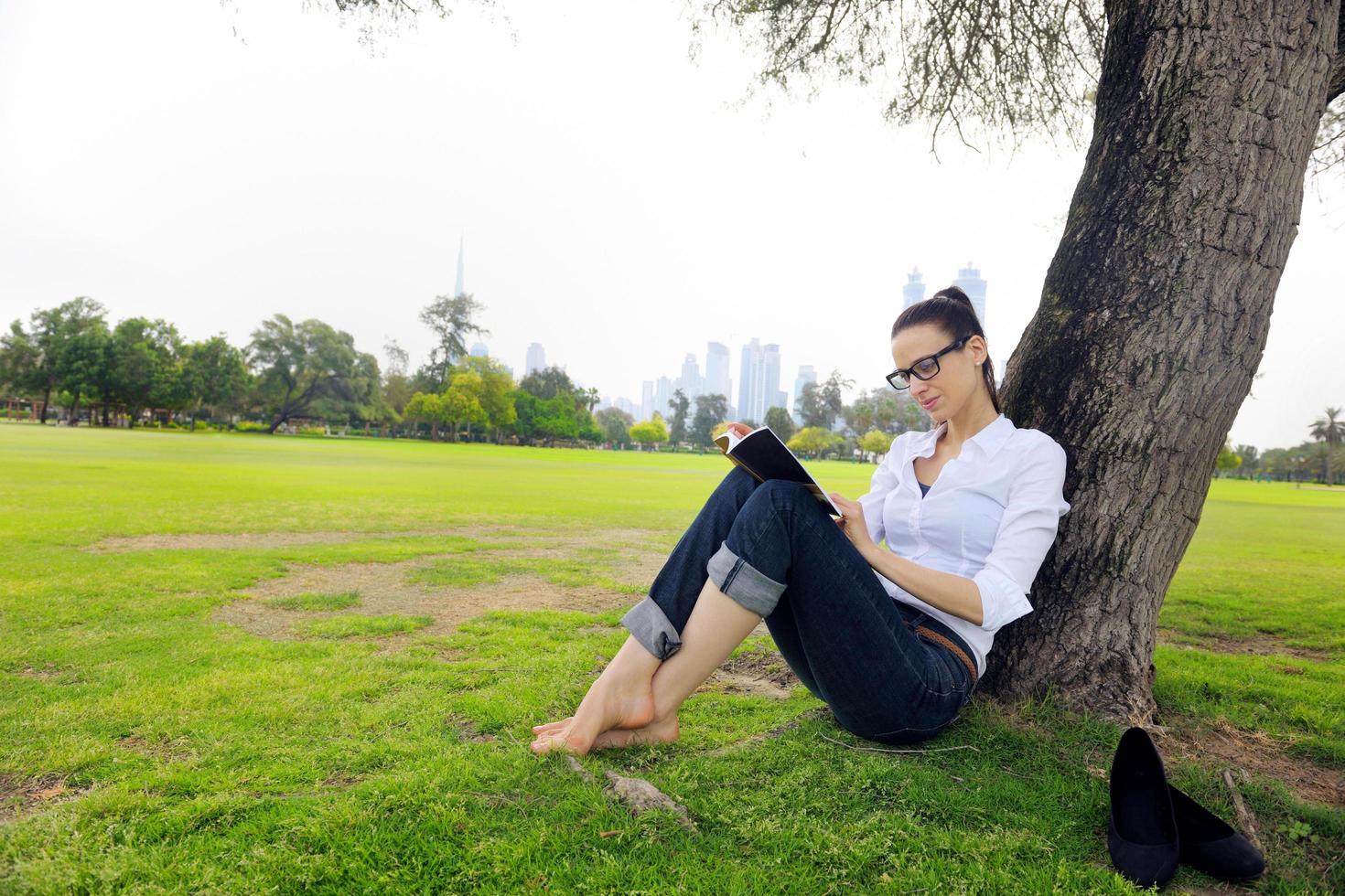 Young woman reading a book in the park photo
