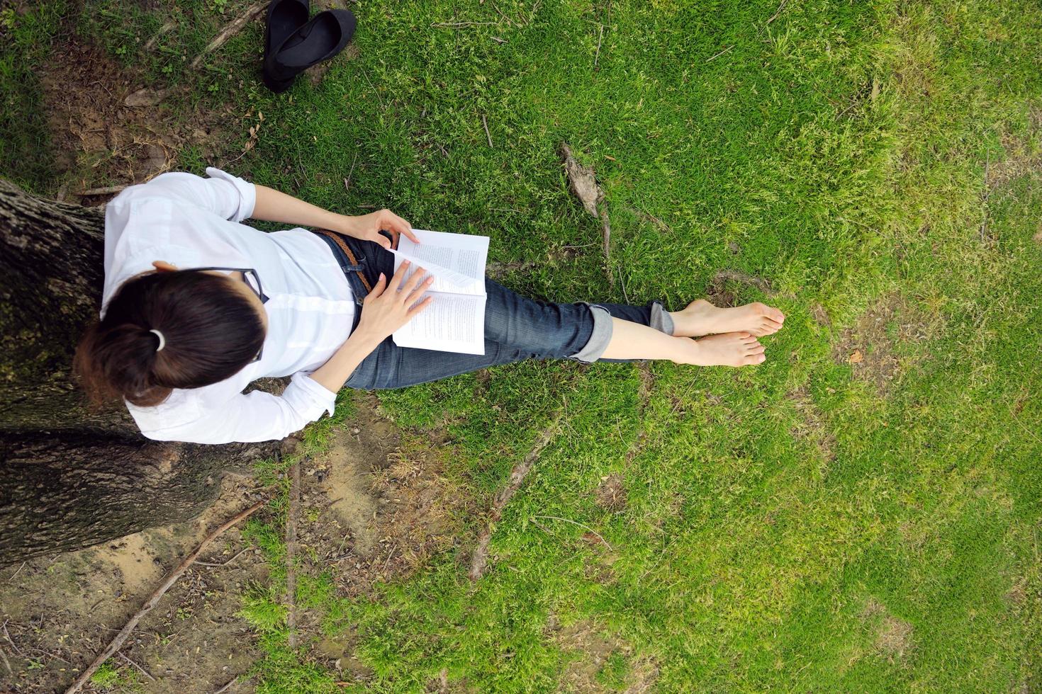 mujer joven leyendo un libro en el parque foto