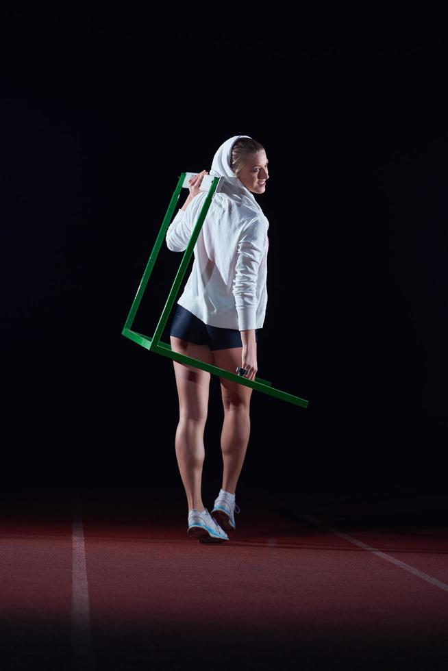 woman athlete jumping over a hurdles photo