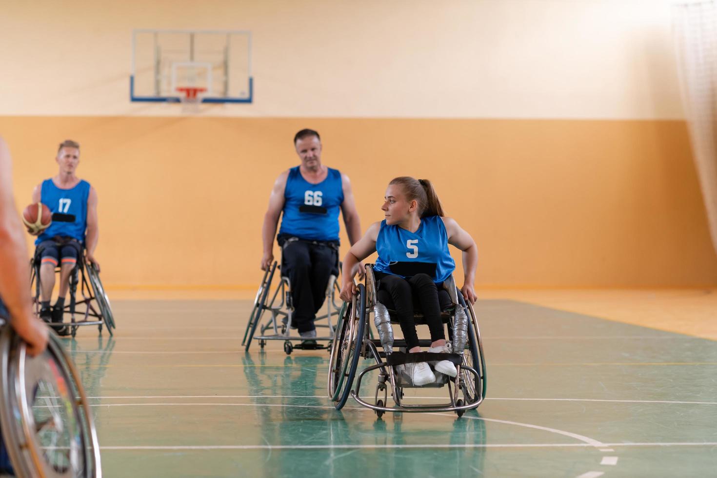 Disabled War veterans mixed race opposing basketball teams in wheelchairs photographed in action while playing an important match in a modern hall. photo