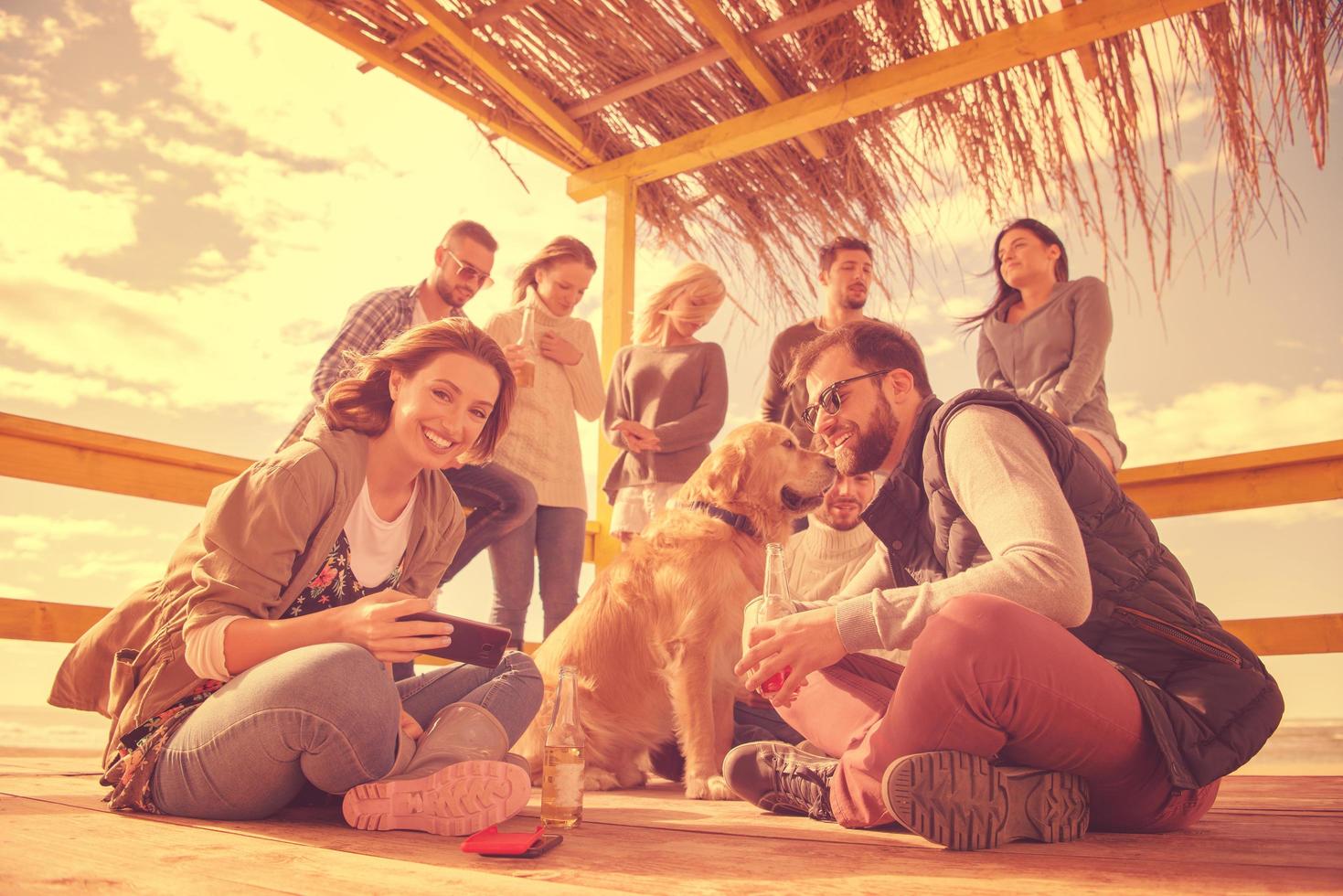 Group of friends having fun on autumn day at beach photo