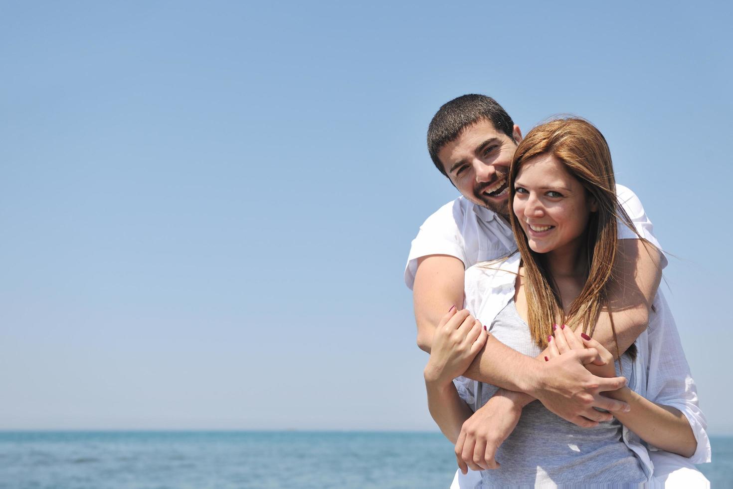 happy young couple have fun on beach photo