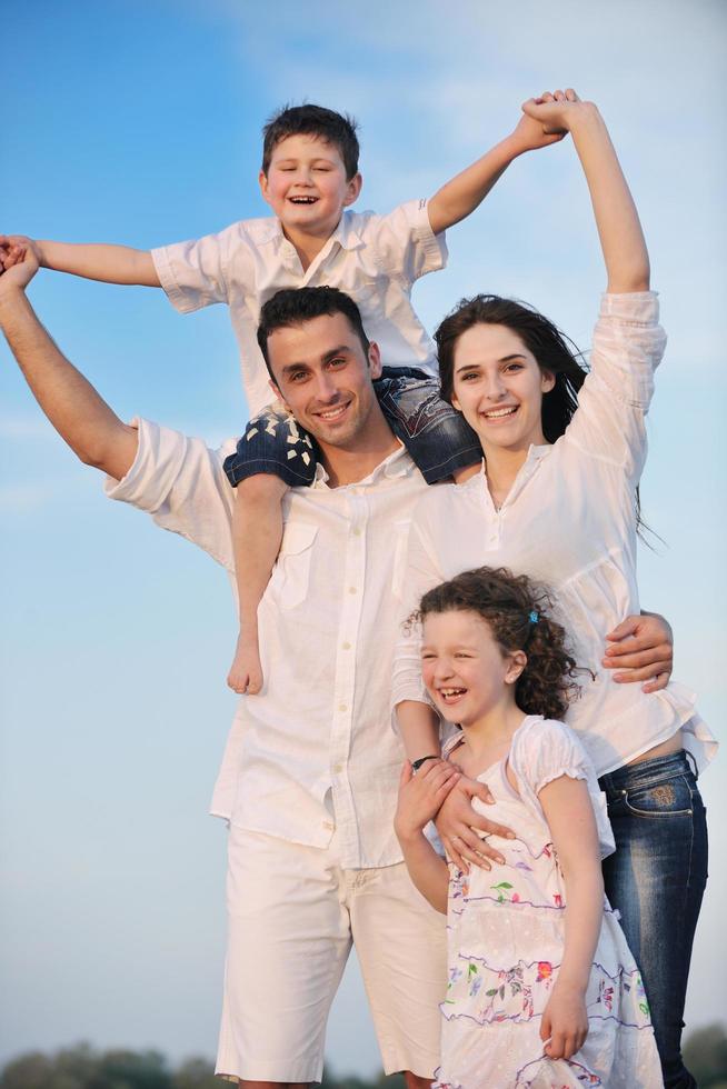 familia joven feliz divertirse en la playa foto