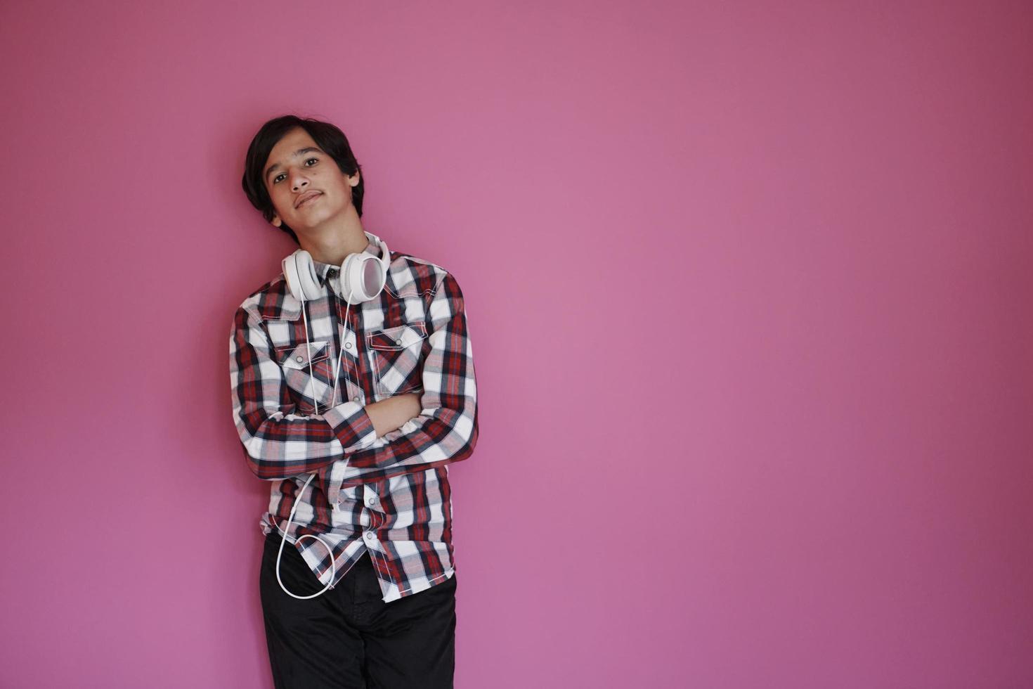 portrait  of smart looking arab teenager  against pink background photo