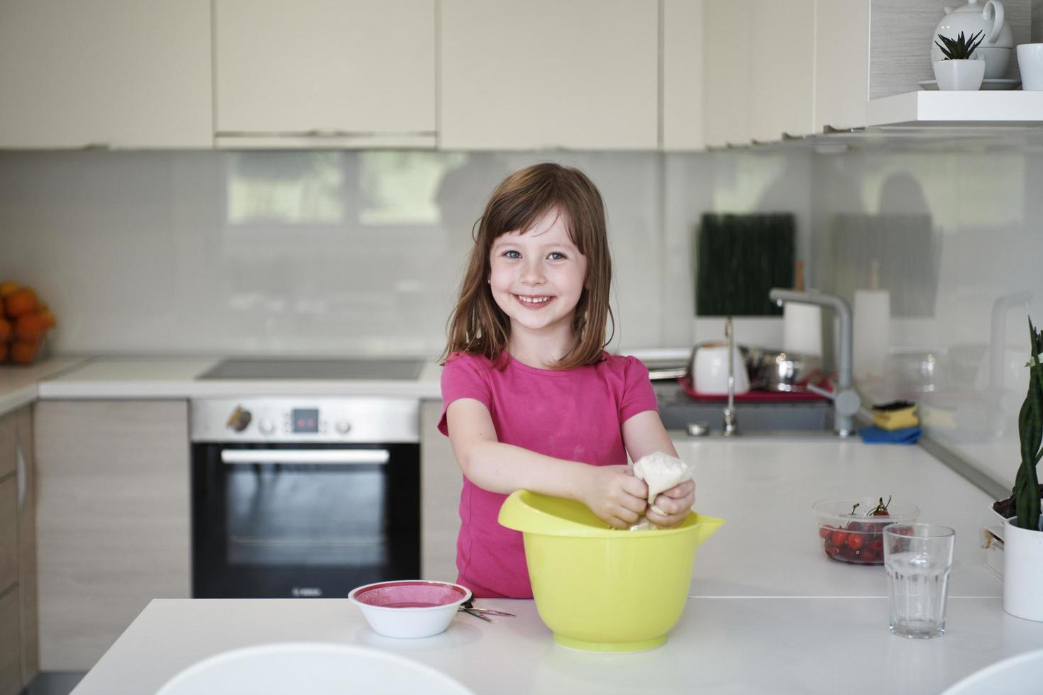 madre e hija jugando y preparando masa en la cocina. foto