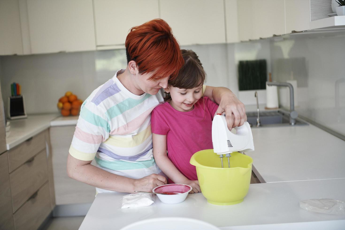 madre e hija jugando y preparando masa en la cocina. foto