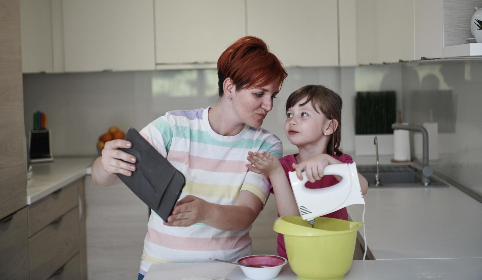 madre e hija jugando y preparando masa en la cocina. foto