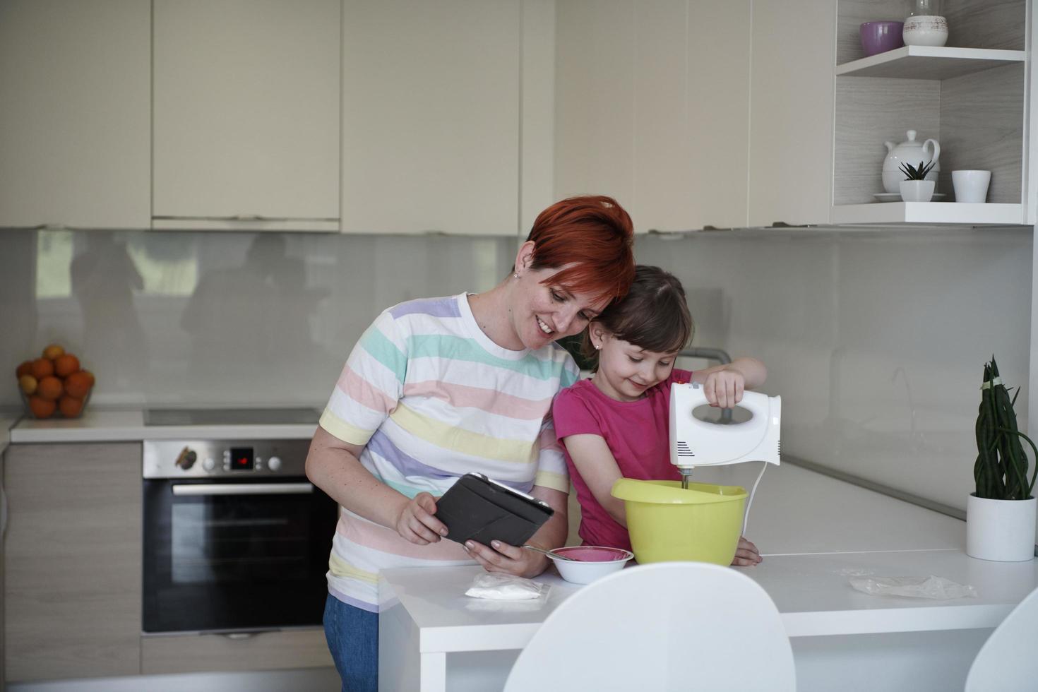 madre e hija jugando y preparando masa en la cocina. foto