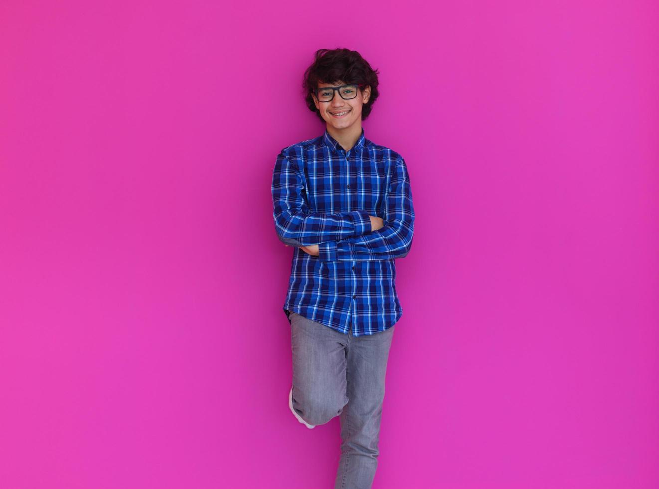 portrait  of smart looking arab teenager  against pink background photo