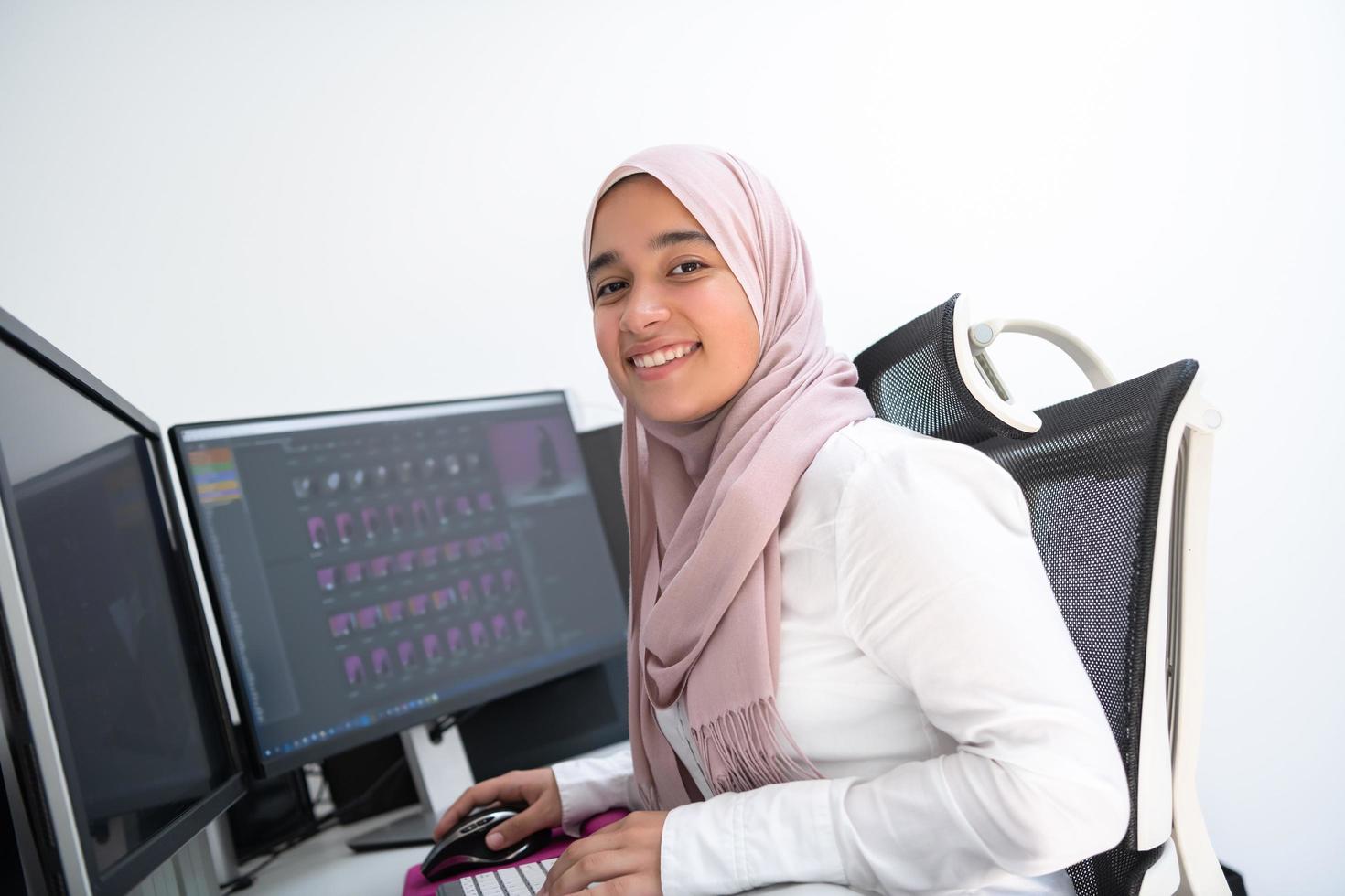 profesional creativa árabe femenina que trabaja en la oficina en casa en una computadora de escritorio con vista superior de monitor de pantalla dual. enfoque selectivo foto