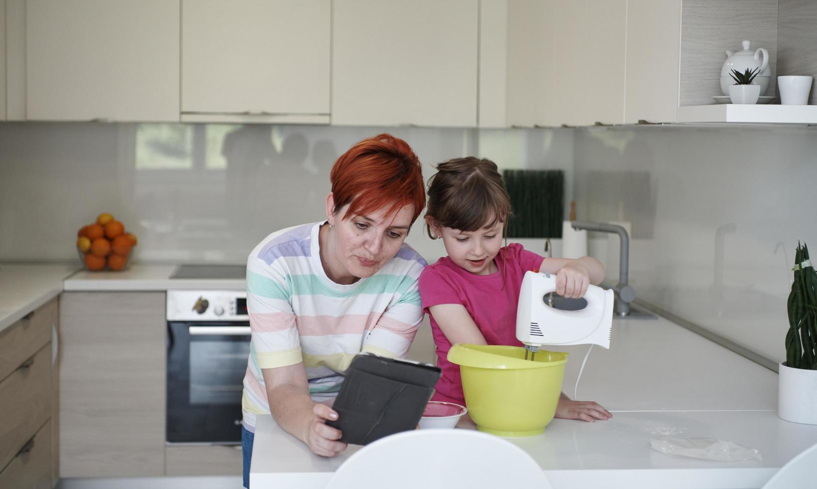 madre e hija jugando y preparando masa en la cocina. foto