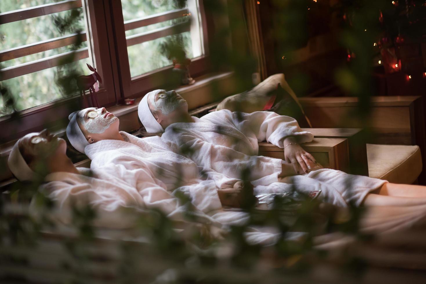 women is getting facial clay mask at spa photo