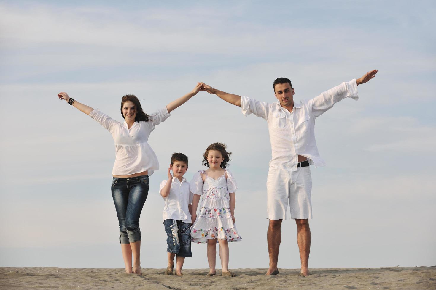 family on beach showing home sign photo