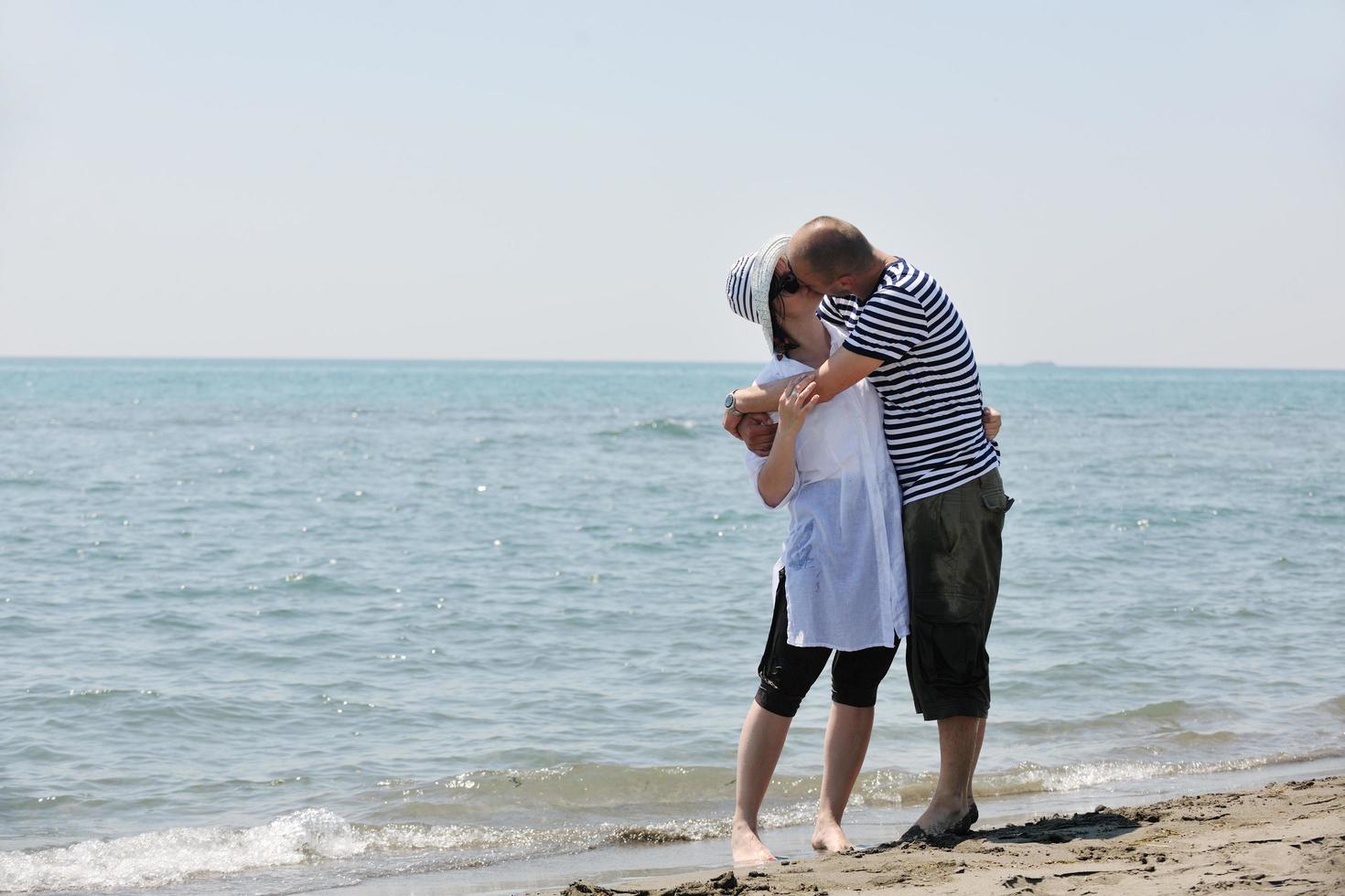 feliz pareja joven divertirse en la playa foto