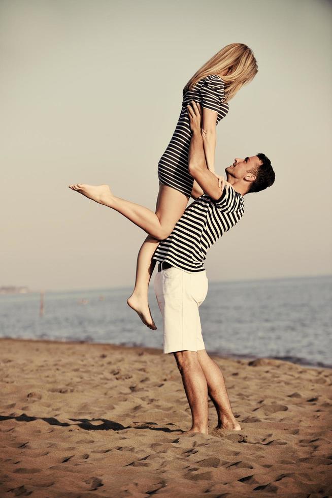 feliz pareja joven divertirse en la playa foto