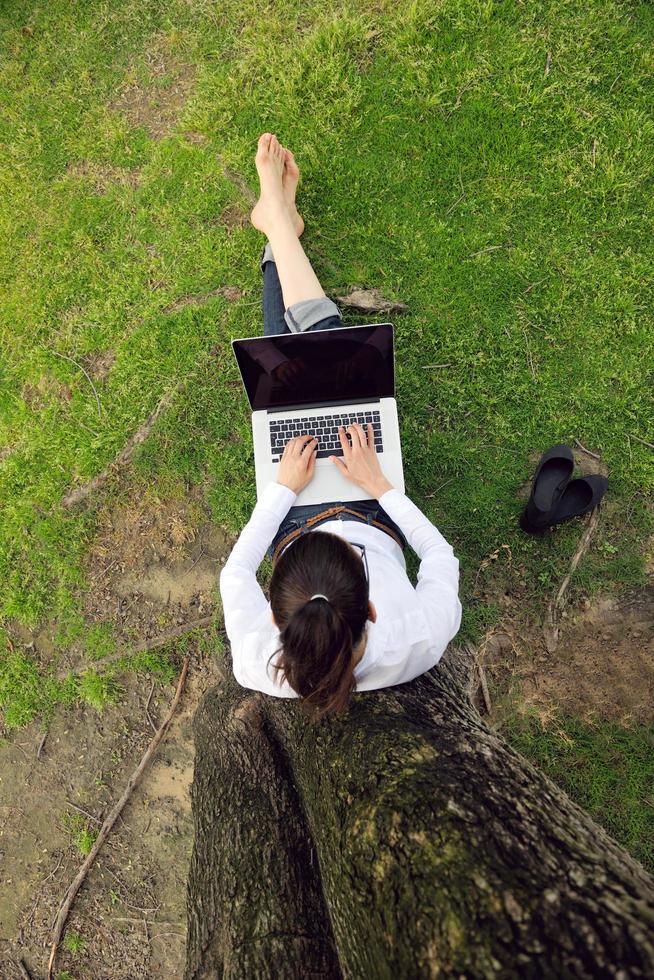 mujer con laptop en el parque foto