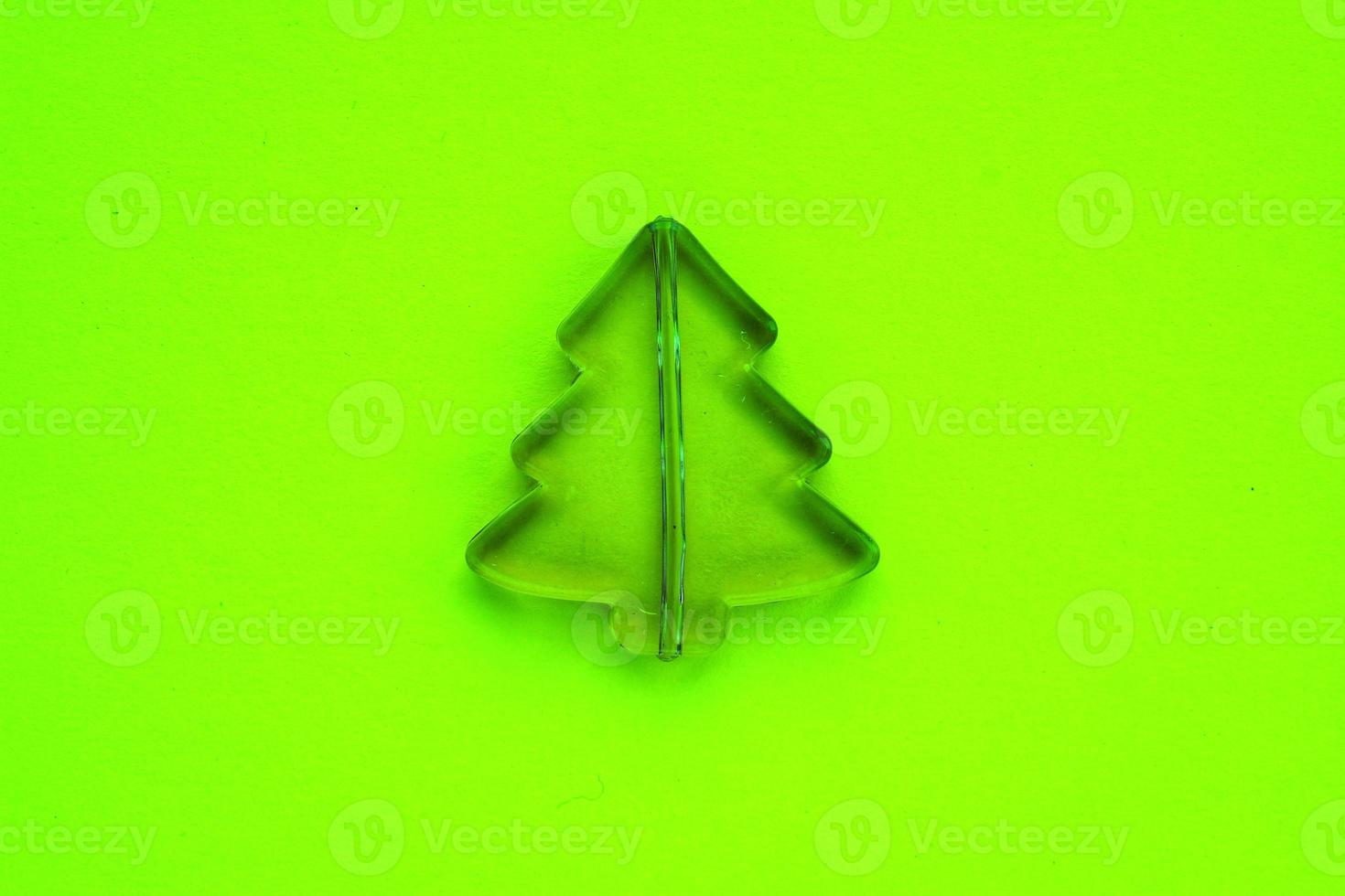 Christmas composition from little plastic pine tree on neon green background. Holidays, winter and celebration concept. Idea for greeting card, poster sale, banner, web. Flat lay, top view. Close-up photo