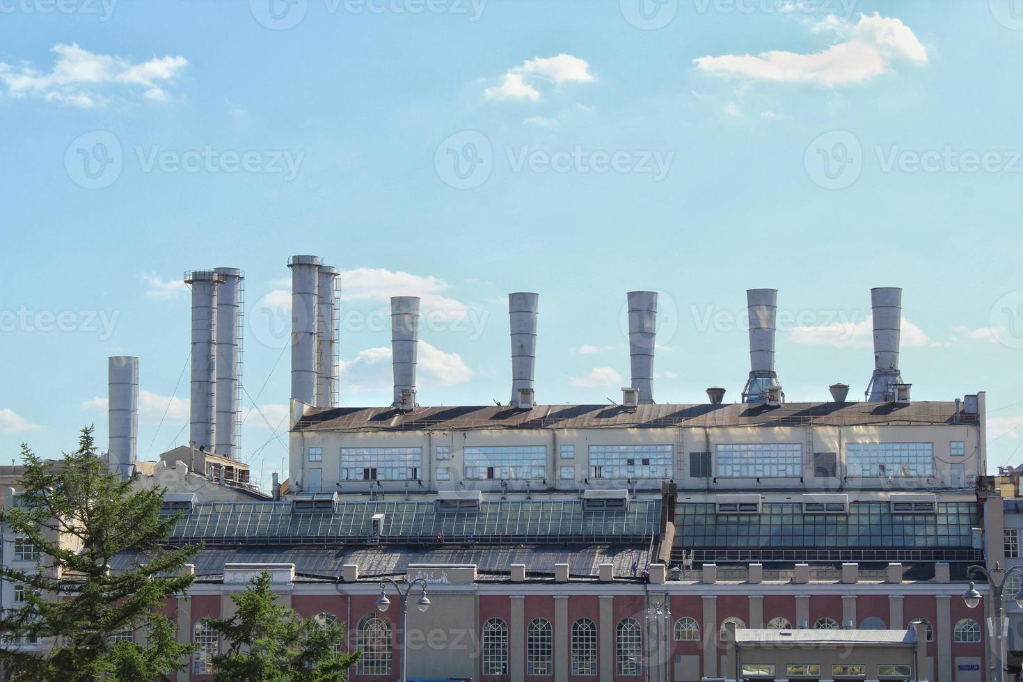 Pipes of thermal power plant on a town. Industrial zone in the city. Producing electrical energy concept. Ecological and environmental issues. System of electricity supply. Saving resources efficient photo