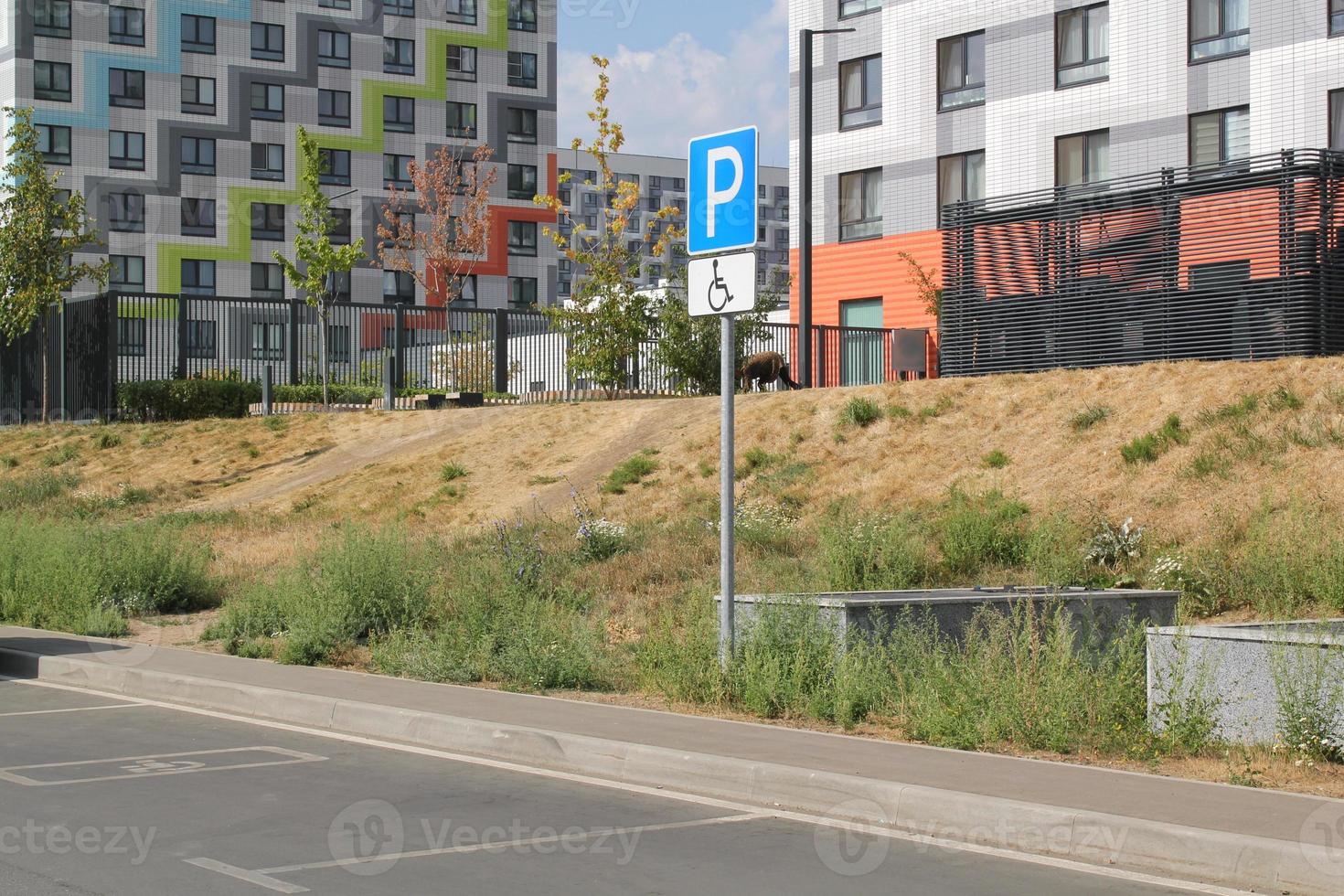 Handicapped parking area spot in the courtyard of the residential complex. Sign of wheelchair and space for visitor cars disabled drivers. Concept of comfortable barrier-free urban environment in city photo