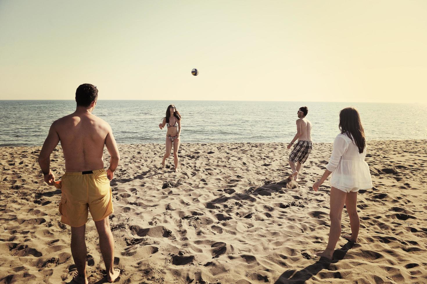 young people group have fun and play beach volleyball photo