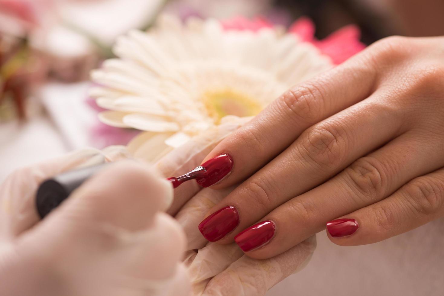 manos de mujer recibiendo una manicura foto