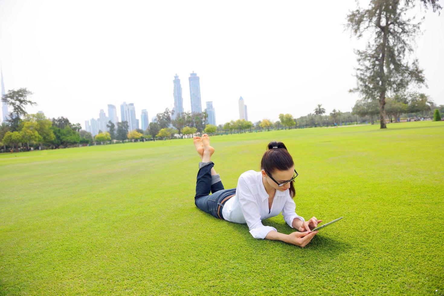 Beautiful young woman with  tablet in park photo