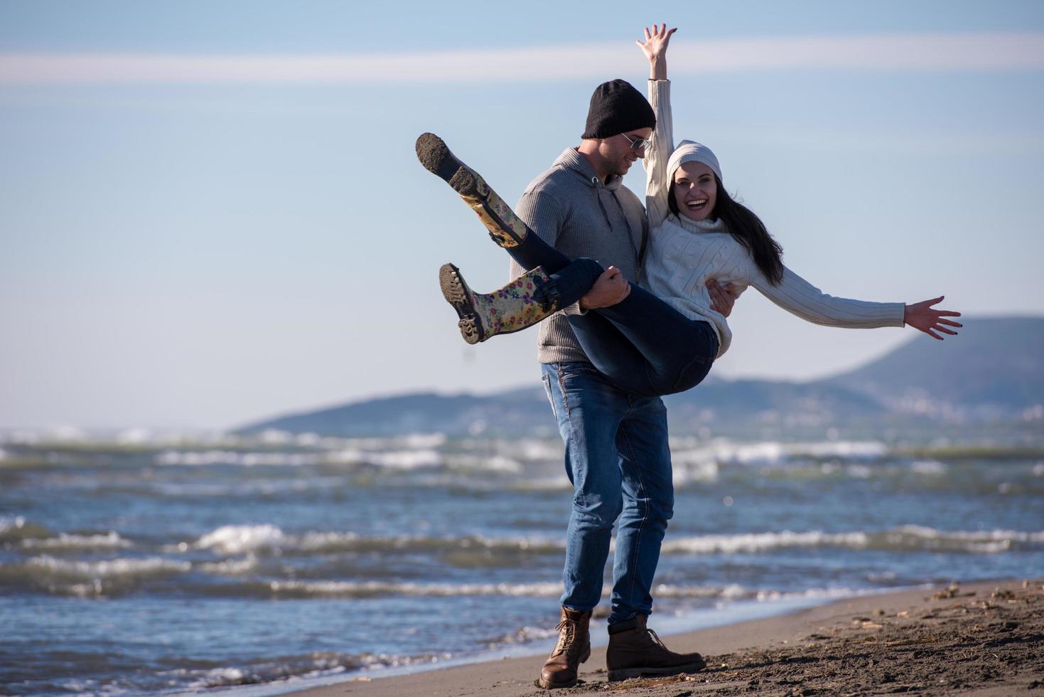 amorosa pareja joven en una playa en el día soleado de otoño foto