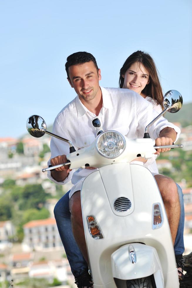 Portrait of happy young love couple on scooter enjoying summer time photo