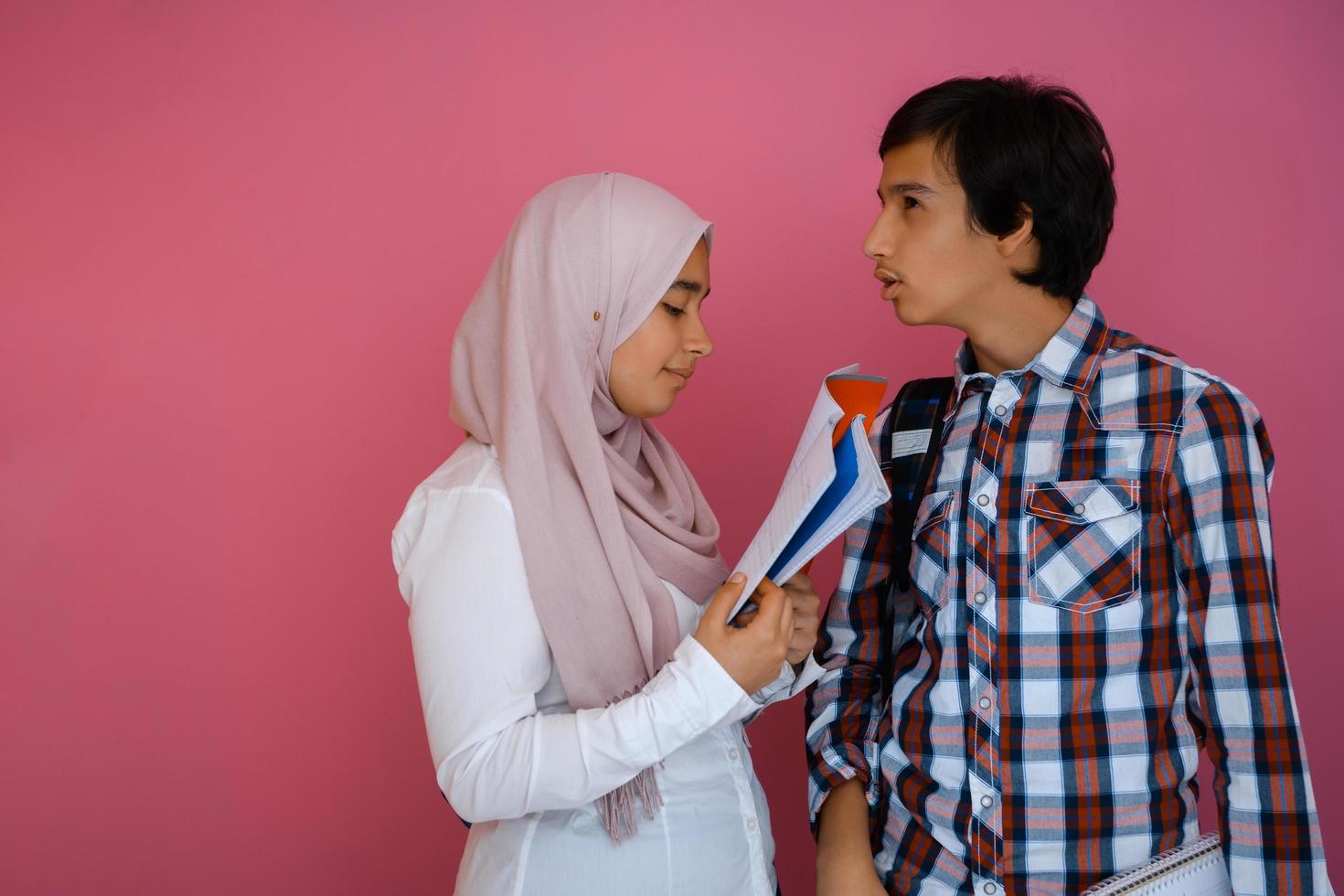 Arabic teenagers group, students team walking forward in future and back to school concept pink background. Selective focus photo