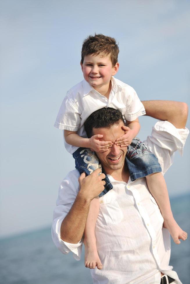 happy father and son have fun and enjoy time on beach photo