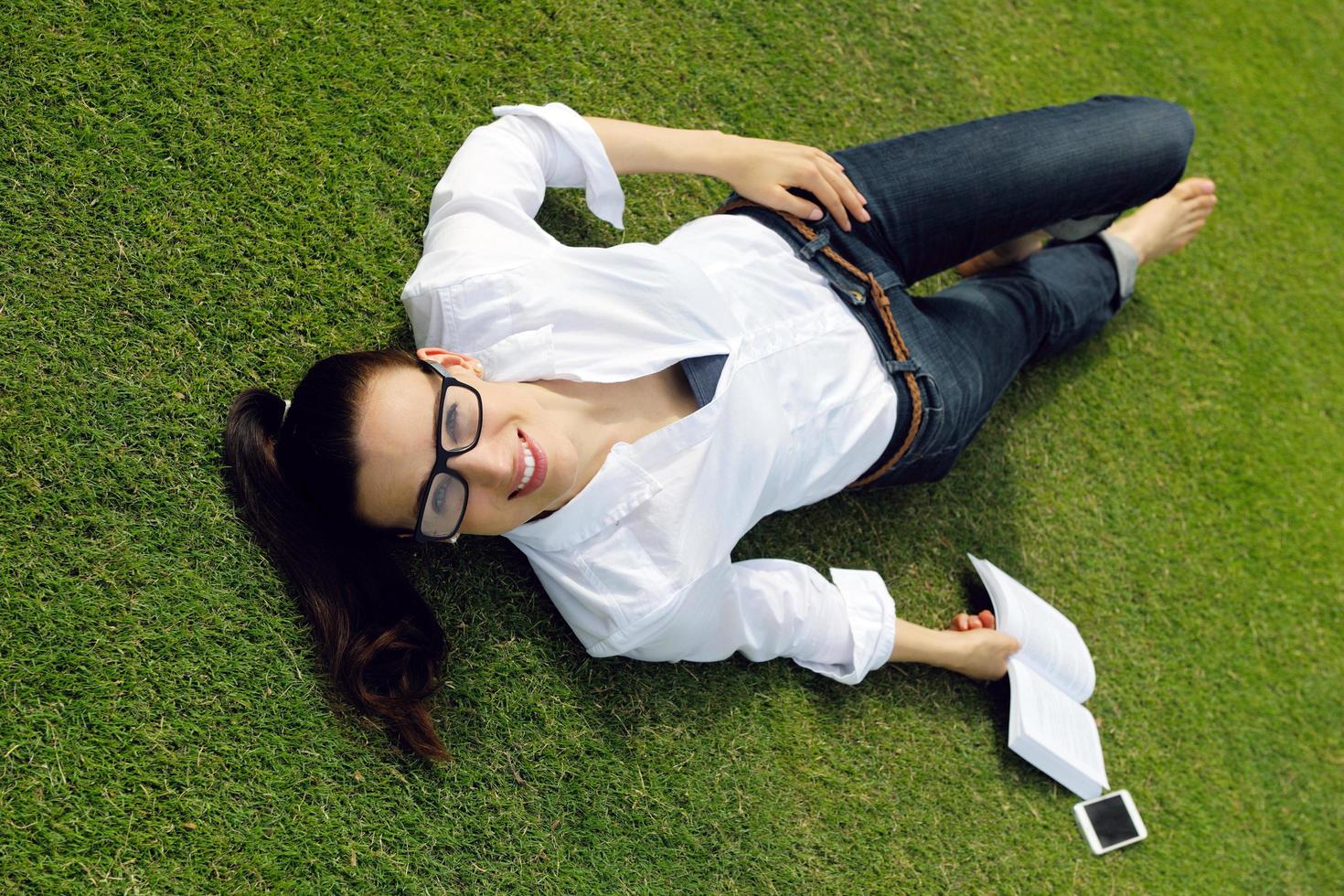 mujer joven leyendo un libro en el parque foto