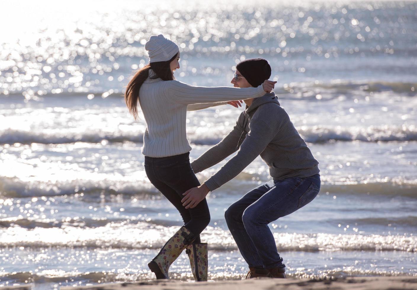 amorosa pareja joven en una playa en el día soleado de otoño foto