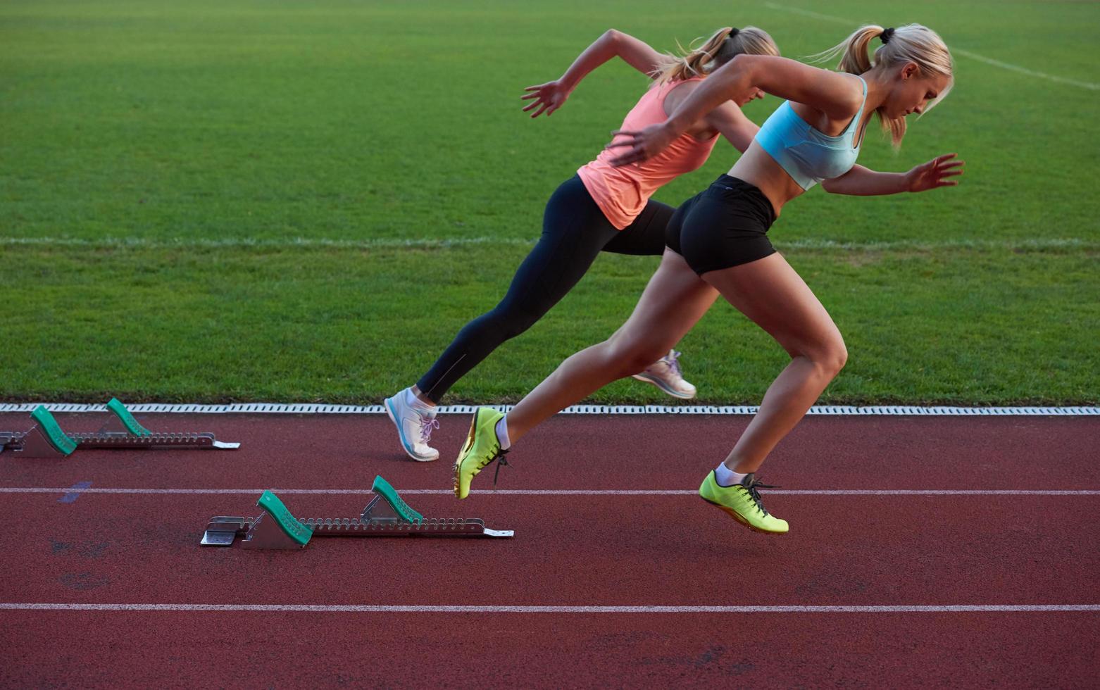 woman  sprinter leaving starting blocks photo