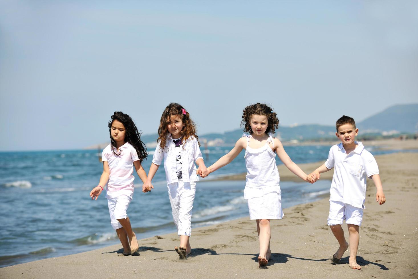 happy child group playing  on beach photo