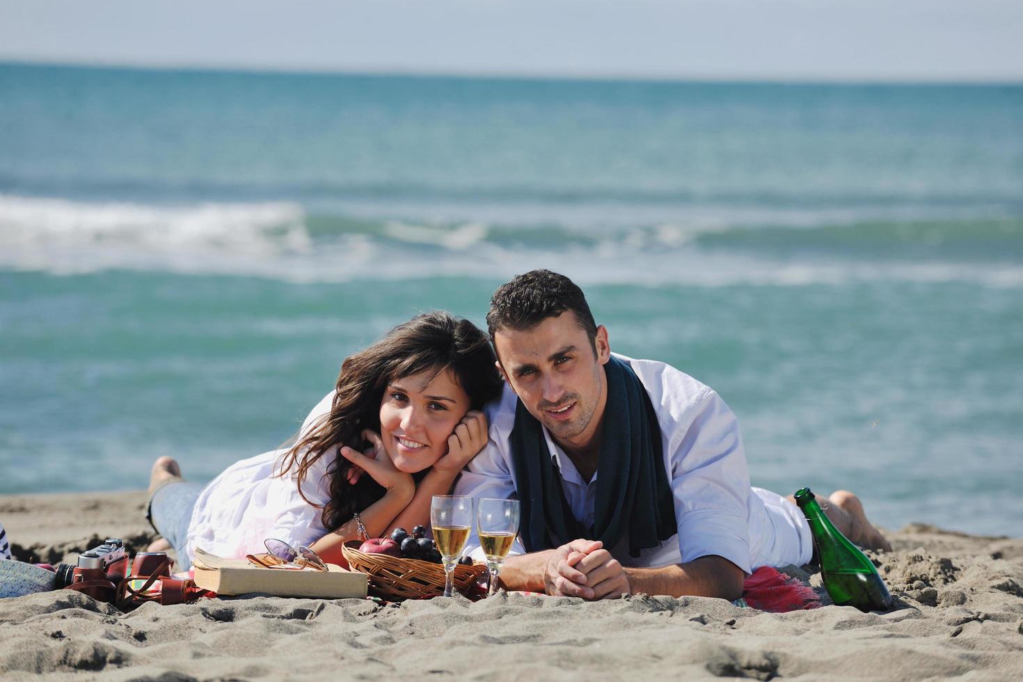 young couple enjoying  picnic on the beach photo