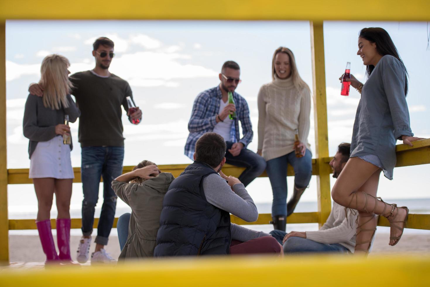 grupo de amigos divirtiéndose el día de otoño en la playa foto