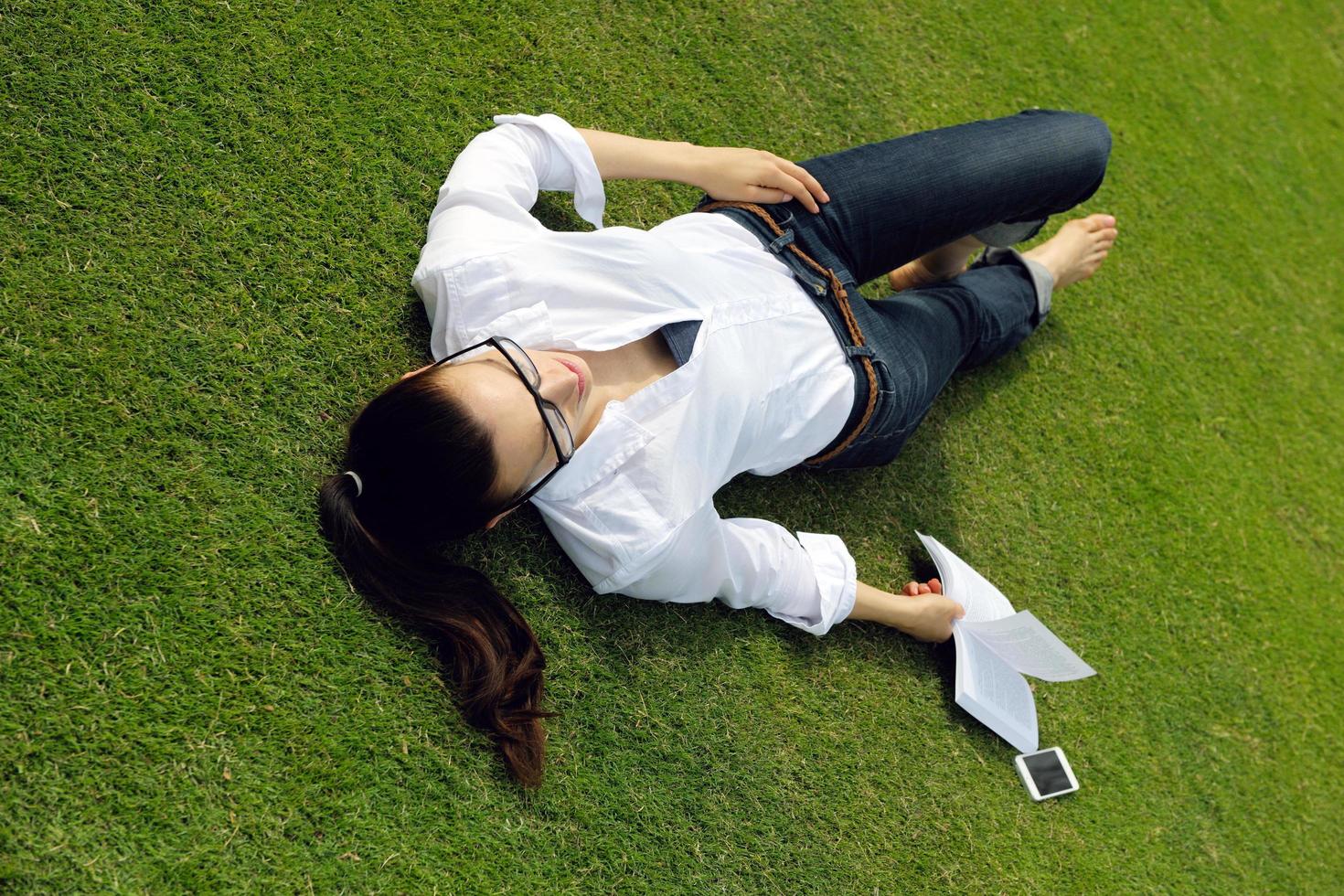 mujer joven leyendo un libro en el parque foto