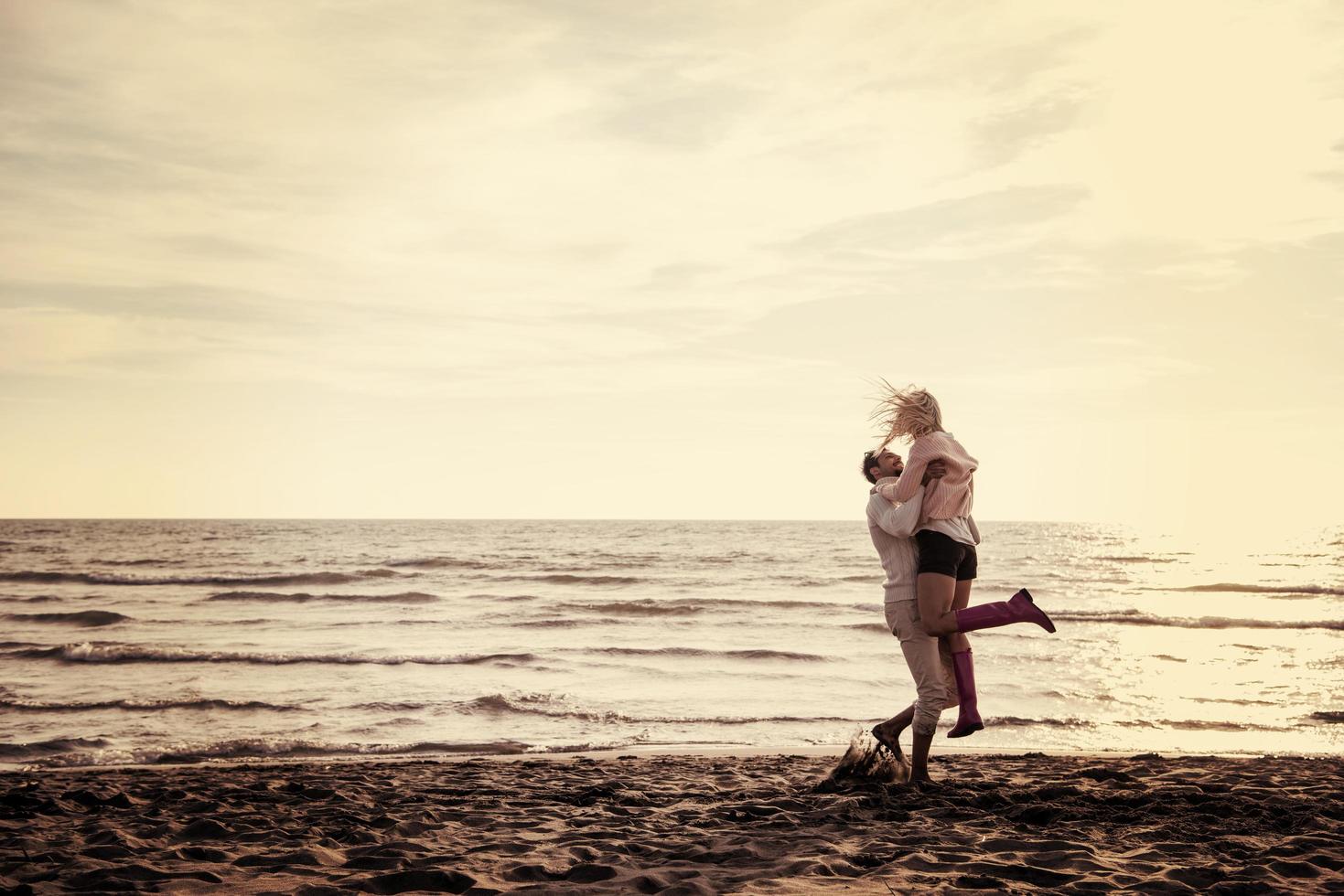 Loving young couple on a beach at autumn sunny day photo