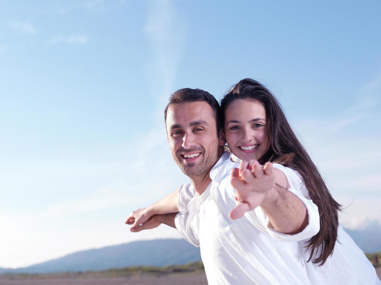 pareja joven en la playa divertirse foto