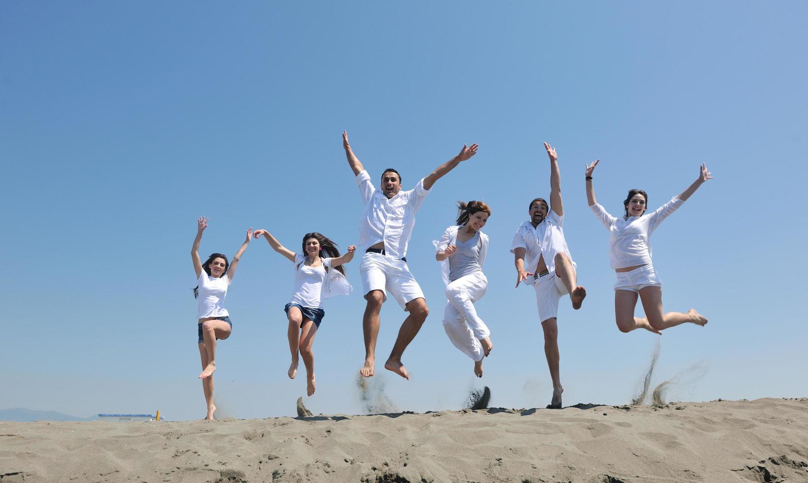 grupo de gente feliz divertirse y correr en la playa foto