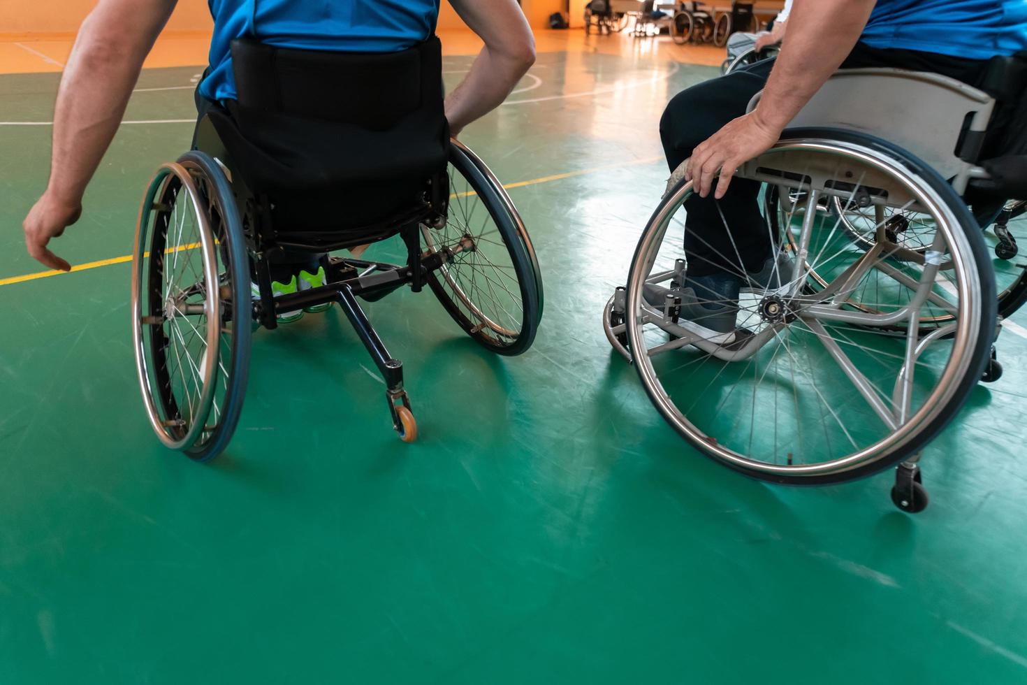 Close up photo of wheelchairs and handicapped war veterans playing basketball on the court