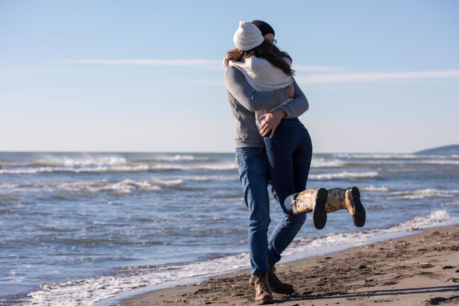 Loving young couple on a beach at autumn sunny day photo