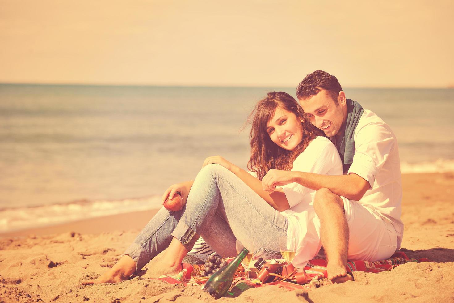 young couple enjoying  picnic on the beach photo