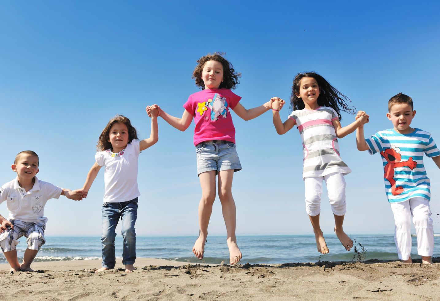 happy child group playing  on beach photo