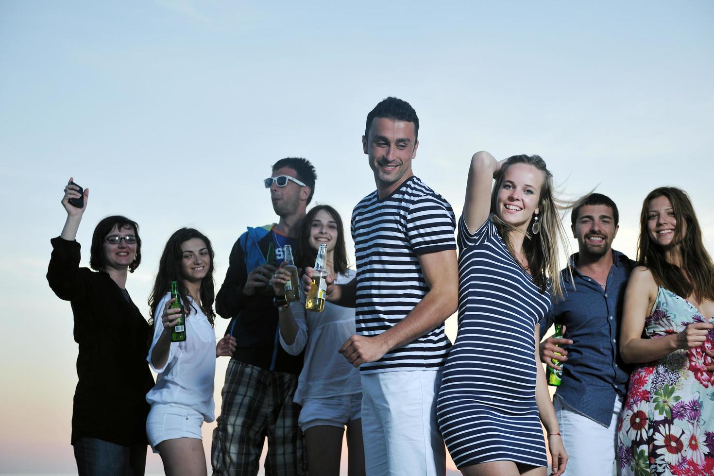 Group of young people enjoy summer  party at the beach photo