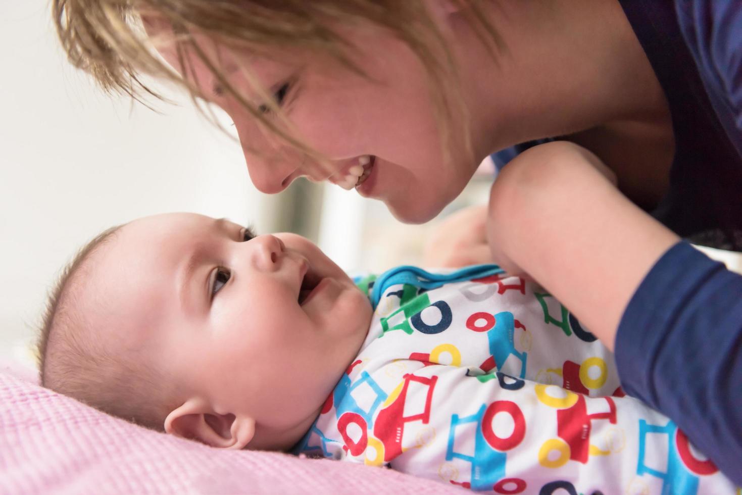 young mother kissing her cute little baby photo