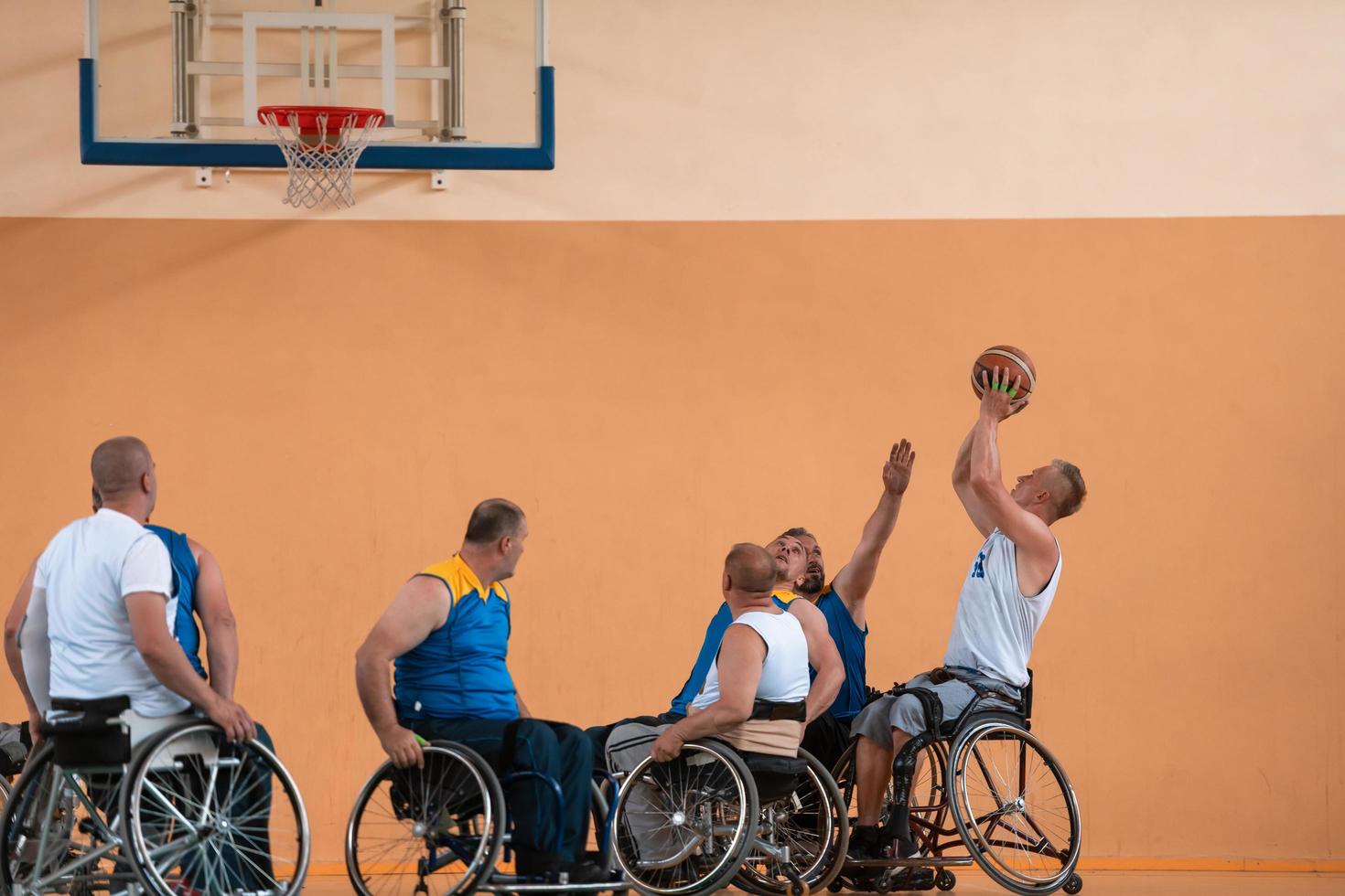 Disabled War veterans mixed race and age basketball teams in wheelchairs playing a training match in a sports gym hall. Handicapped people rehabilitation and inclusion concept photo