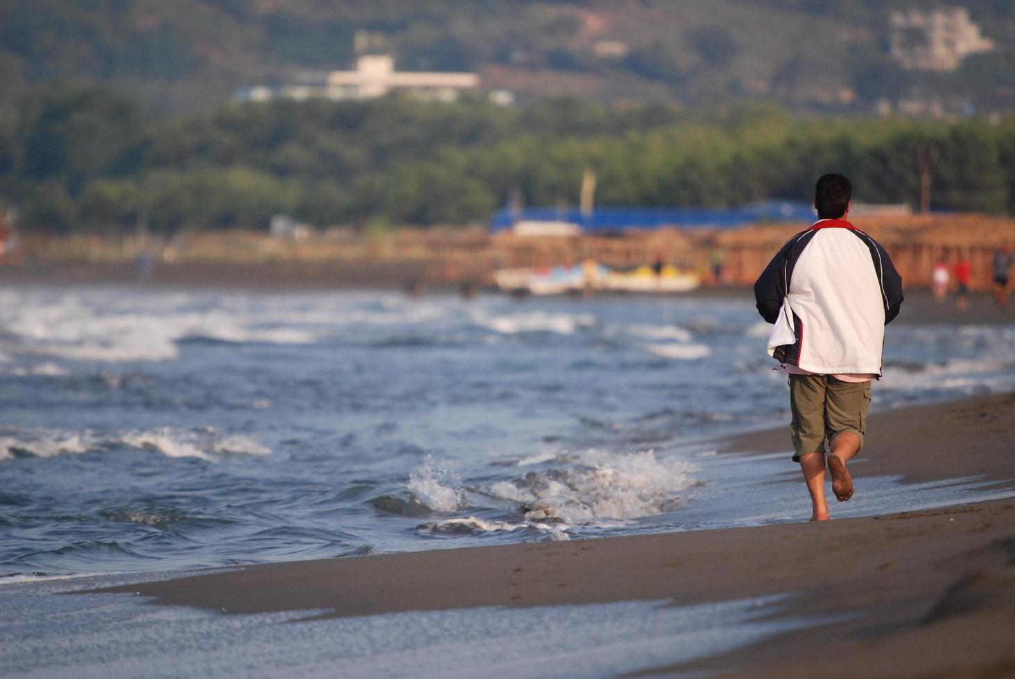 man running on beach photo